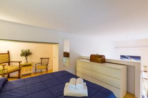1 dormitorio con 1 cama azul y 2 pares de zapatillas en Grifeo - Quiet and Relaxing Flat on Panoramic Route en Nápoles