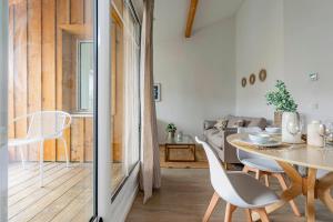 a dining room and living room with a table and chairs at Nagaya - Petit nid avec terrasse à 100m du bassin in La Teste-de-Buch +9 photos