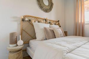 a bedroom with a bed with white sheets and pillows at Nagaya - Petit nid avec terrasse à 100m du bassin in La Teste-de-Buch