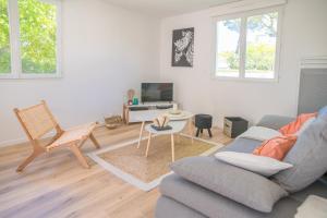 salon z kanapą i stołem w obiekcie Villa Nina- Maison cocon cosy w mieście La Teste-de-Buch