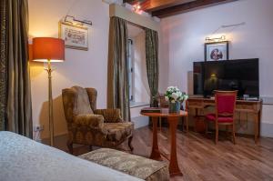 Habitación de hotel con cama, escritorio y TV. en The Pucic Palace en Dubrovnik