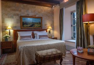 een slaapkamer met een groot bed en een tafel bij The Pucic Palace in Dubrovnik