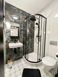 een badkamer met een douche, een wastafel en een toilet bij Przestronny apartament w centrum miasta in Radom