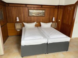 two beds in a room with wood paneling at Hotel Sonne - Haus 2 in Idstein