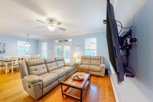 a living room with a couch and a flat screen tv at Villages of Crystal Beach CoCo Bliss in Destin