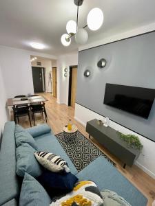 a living room with a blue couch and a tv at Przestronny apartament w centrum miasta in Radom