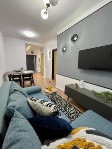 a living room with a blue couch and a flat screen tv at Przestronny apartament w centrum miasta in Radom