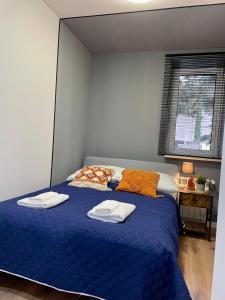 a bedroom with a blue bed with two towels on it at Przestronny apartament w centrum miasta in Radom