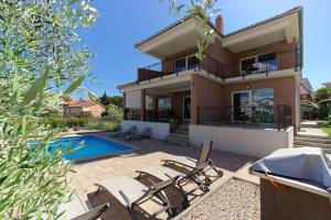 a villa with a swimming pool and a house at Villa Nerium in Malinska