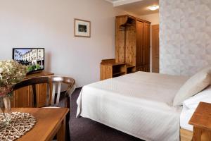 Un dormitorio con una cama y una mesa con un jarrón de flores en Hotel Gendorf en Vrchlabí