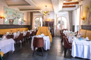 a dining room with tables with white tablecloths at The Pucic Palace in Dubrovnik