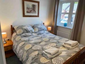 a bed with pillows on it in a bedroom at Modern 2 bed nestled in the Abergavenny hills in Abergavenny