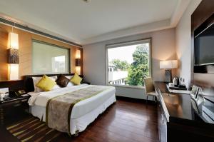 a bedroom with a large bed and a large window at Quality Inn Gurgaon in Gurgaon
