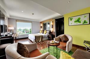 a hotel room with a bed and a living room at Quality Inn Gurgaon in Gurgaon