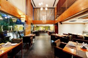 a dining room with wooden tables and chairs at Quality Inn Gurgaon in Gurgaon