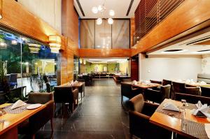 comedor con mesas y sillas de madera en Quality Inn Gurgaon, en Gurgaon