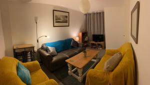 a living room with two couches and a table at Modern 2 bed nestled in the Abergavenny hills in Abergavenny