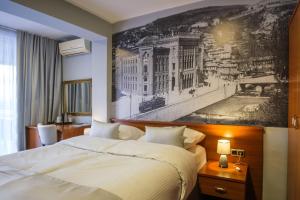 una habitación de hotel con una cama y un cuadro en la pared en Villa Harmony, en Sarajevo