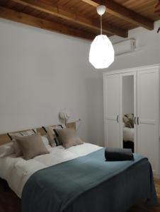 una camera con un grande letto e una luce a ciondolo di Azahar a Siviglia