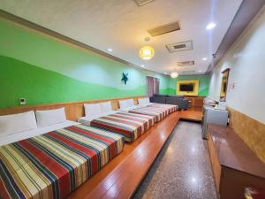 Habitación con 2 camas y pared verde. en Xing Ji Hotel, en Kenting