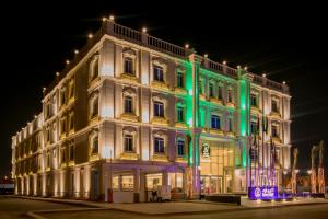 a large white building with green lights on it at Luxury Night Hotel in Riyadh