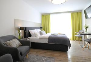 - une chambre avec un lit, un canapé et une chaise dans l'établissement Gandersheimer Boardinghouse, à Bad Gandersheim