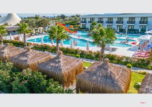 um grupo de guarda-sóis de palha em frente a uma piscina em Assos Barbarossa Special Class Hotel em Behramkale