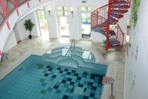 a swimming pool in a house with a tile floor at Alpenchalets Hotel Lambach in Seebruck