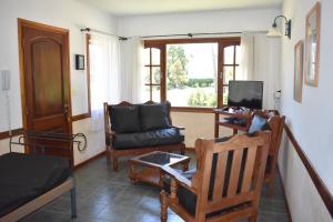 Una sala de estar con un sofá y un televisor. en Complejo Frente al Golf, en Pinamar