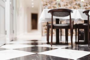 a black and white tile floor with two chairs and a table at Hotel Bastian in Helsinki