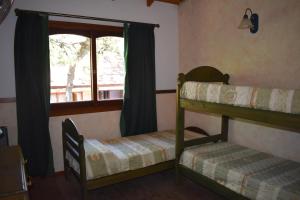 1 dormitorio con 2 literas y ventana en Complejo Frente al Golf en Pinamar