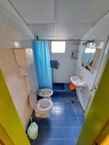 a small bathroom with two toilets and a sink at Cabañas Del Sauce in Paraná