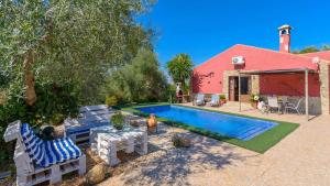 a backyard with a pool and chairs and a house at Casa Rural La Higuera El Gastor by Ruralidays in El Gastor