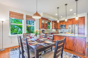a kitchen with a wooden table and chairs and a counter at Pili Mai 1L in Koloa