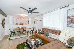 a living room with a brown leather couch and a table at East Nashville Nook Best of Both Worlds in Nashville +18 photos