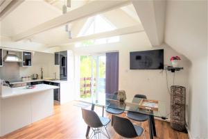 a kitchen and dining room with a glass table and chairs at The Penthouse Canterbury - Cathedral View in Canterbury