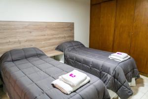 two beds in a room with towels on them at Departamento Serena in San Juan