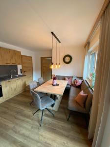 Il comprend une cuisine et un salon avec une table et un canapé. dans l'établissement Apart Helena, à Mayrhofen