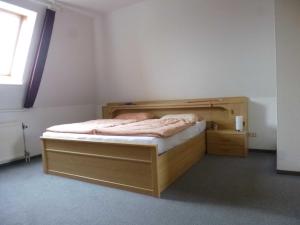 a small bedroom with a wooden bed and a window at DKK7 Ferienwohnung Abendsonne F in Niendorf