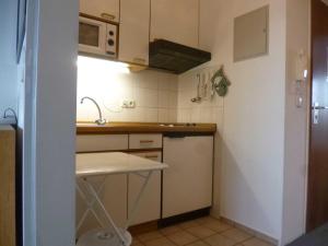 a small kitchen with a sink and a microwave at DKK7 Ferienwohnung Abendsonne F in Niendorf