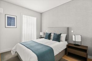 a bedroom with a large bed with blue pillows at Mirabilis Apartments - AAA23 in Lisbon