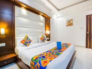 una habitación de hotel con una cama con una manta colorida en FabHotel Star Delhi Airport, en Nueva Delhi