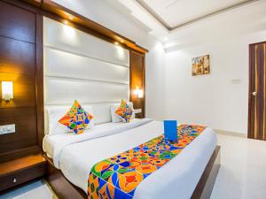 a hotel room with a bed with a colorful blanket at FabHotel Star Delhi Airport in New Delhi