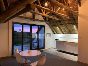 a kitchen and dining room with a table and chairs at Acara Guest Cottages in Stellenbosch