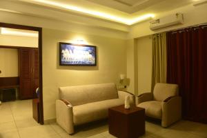 a living room with a couch and a chair at Hotel Seven Hills in Trivandrum