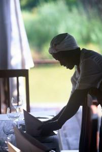 a man sitting at a table using a laptop computer at Mogalakwena River Lodge in Alldays