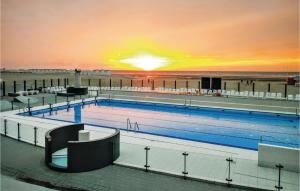 a large swimming pool with a sunset in the background at Goudstrand in Oostduinkerke