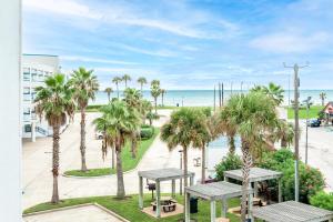 a view of the beach from a balcony with palm trees at Casa Del Mar Skip to the Beach 294 in Galveston
