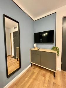 een kamer met een spiegel en een dressoir met een televisie bij Przytulne mieszkanie w centrum miasta in Radom