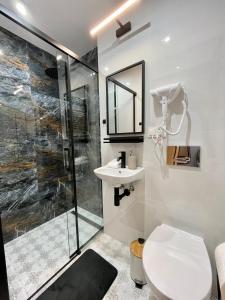 een badkamer met een douche, een toilet en een wastafel bij Przytulne mieszkanie w centrum miasta in Radom